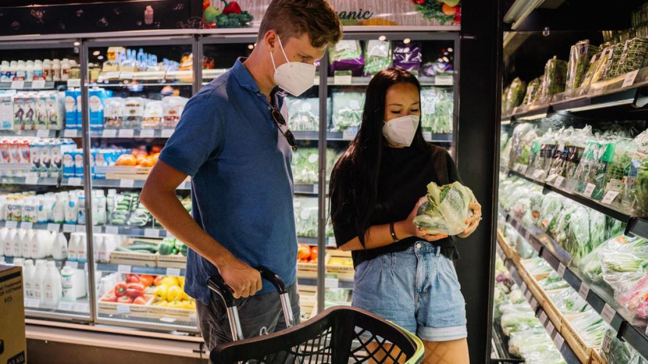 Couple shopping in produce section. 